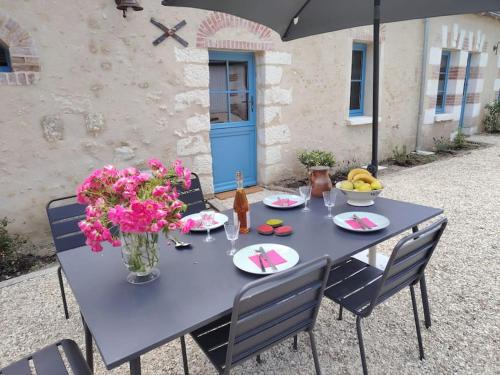 une table bleue avec un vase de fleurs sur elle dans l'établissement Closerie de Montaimé, à Amboise