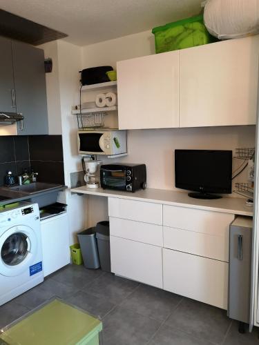 une cuisine avec une machine à laver et un lave-linge dans l'établissement Bien au calme, à La Londe-les-Maures