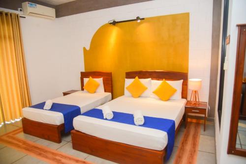 two beds in a room with two lamps and a bed sidx sidx sidx at Royal Tusker Hotel in Udawalawe