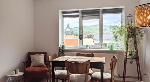 Un comedor con mesa y sillas y una ventana. en Downtown mountain view two bedroom apartment 4th floor, en Gura Humorului