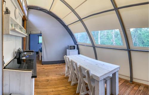 a table and chairs in a room with windows at Stunning StaCaravan In Hoogersmilde in Hoogersmilde