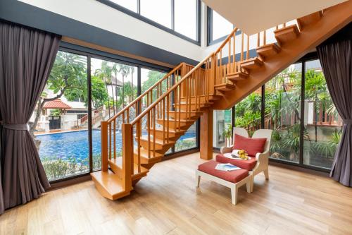 a living room with a staircase and a chair at The Briza Beach Resort, Samui - SHA Plus in Chaweng