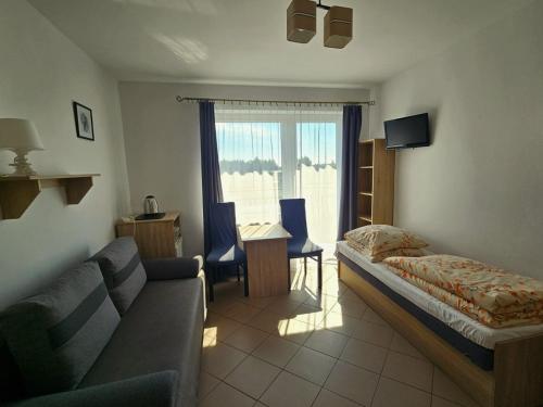 a living room with a couch and a bed at Willa Ibis in Karwia