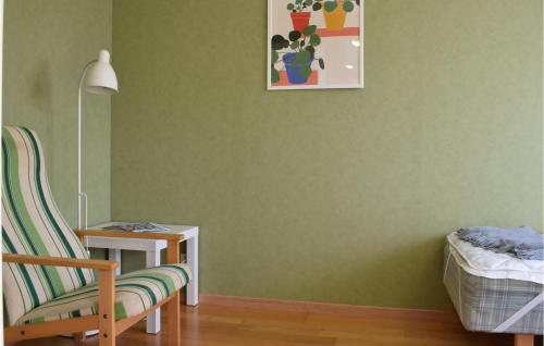 a room with a green wall with a chair and a table at Stunning Apartment In Blomstermåla in Blomstermåla