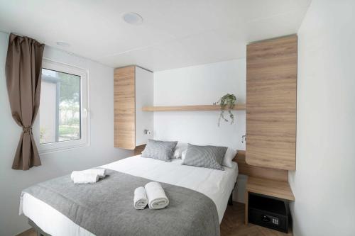 a bedroom with a bed with white towels on it at Camping Park Umag Mobile Homes in Umag