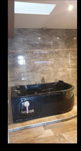 une baignoire noire dans une pièce avec un mur carrelé dans l'établissement Villa 190 m avec Piscine proche Aix-en-Provence, à Éguilles