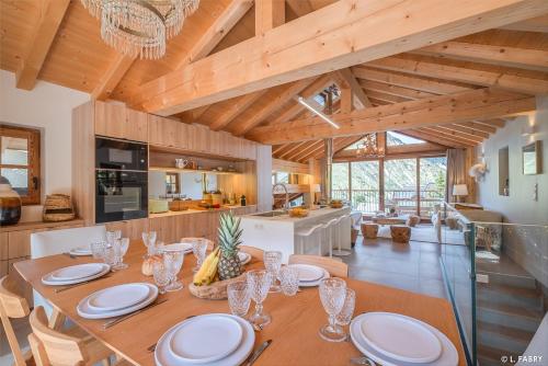 une cuisine et une salle à manger avec une table et des chaises dans l'établissement Odalys Chalet le Duc Blanc, à Saint-Martin-de-Belleville