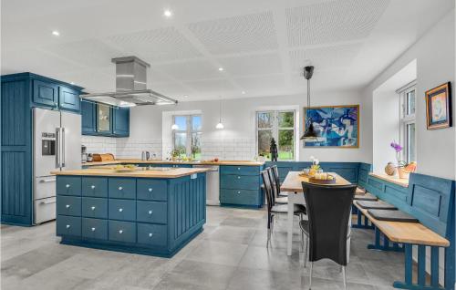 a kitchen with blue cabinets and a table and chairs at Cozy Apartment In Kværndrup With Wifi in Kværndrup