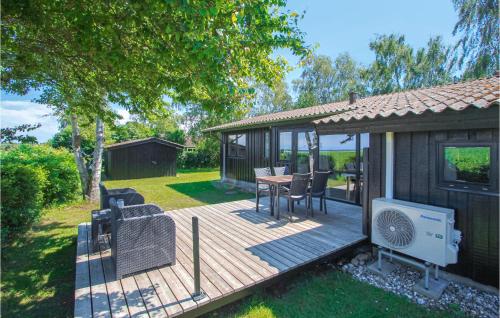 Una terraza de madera con una mesa y sillas. en 3 Bedroom Lovely Home In Samsø, en Nordby