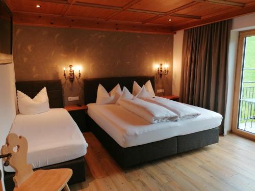a hotel room with two beds and a window at Tirol Appartement Haus Zillertal in Zell am Ziller