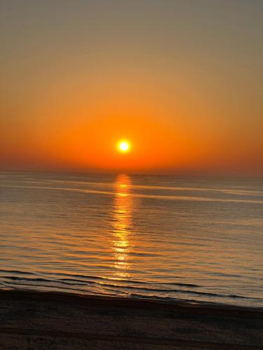 a sunset on the beach with the sun setting at Hotel Meridional in Guardamar del Segura