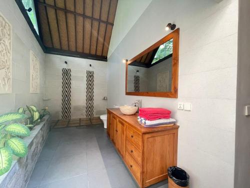 a bathroom with a wooden sink and a mirror at Bali Santi Bungalows in Candidasa