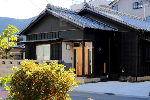 a black and white house with a front door at ぽつぽつあん in Ise