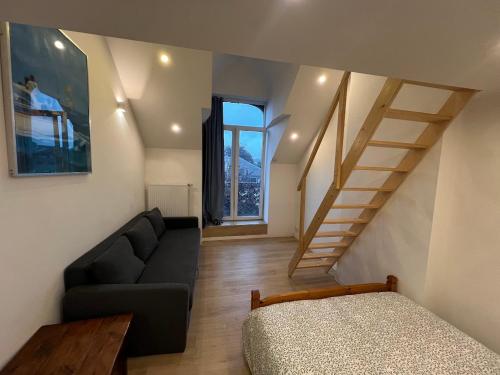 un salon avec un canapé et un escalier dans l'établissement Duplex sympa Verviers, à Verviers