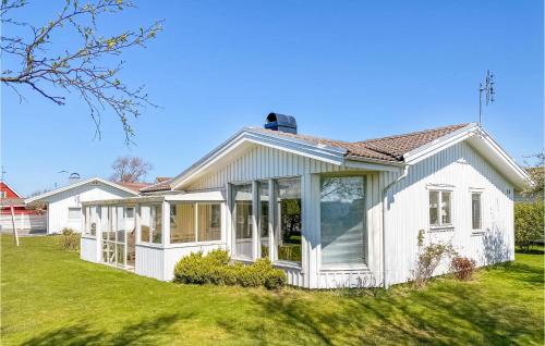 a white house with large windows on a lawn at 3 Bedroom Awesome Home In Falkenberg in Falkenberg