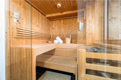 a sauna with wood paneling and a glass wall at AvenidA Panorama Suites in Kaprun