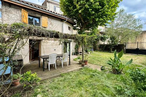 - une terrasse en bois avec une table et des chaises dans la cour dans l'établissement Escapade au fond du jardin, à Saulce-sur-Rhône
