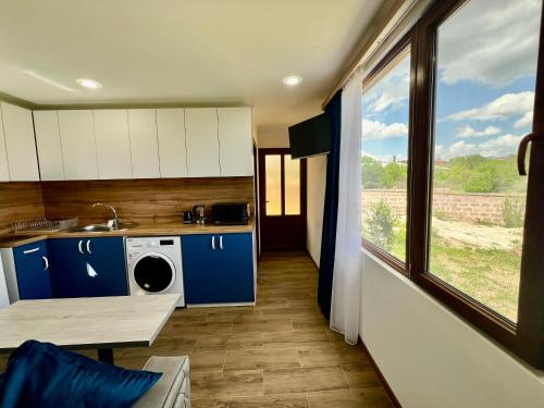 a kitchen with blue and white cabinets and a window at Luxury Cottage next to observatory in Byurakan
