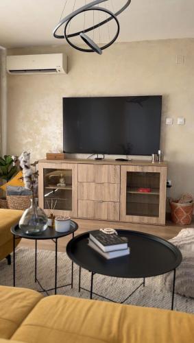 a living room with a tv and a table at Славянска резиденс - Спокойствие в центъра на Пловдив in Plovdiv