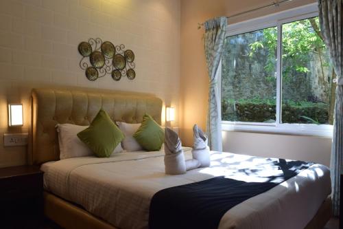 a bedroom with a large bed with a window at Avadale Kodaikanal - Stag Groups Not Allowed in Kodaikānāl
