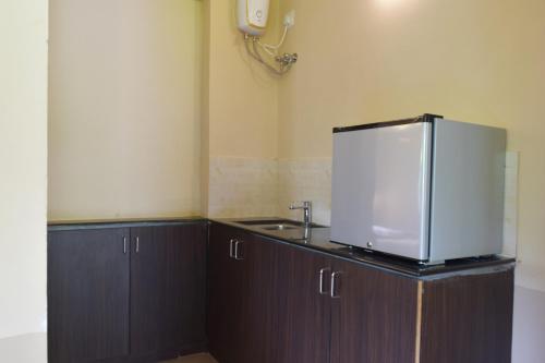 a kitchen with a sink and a refrigerator on a counter at Avadale Kodaikanal - Stag Groups Not Allowed in Kodaikānāl