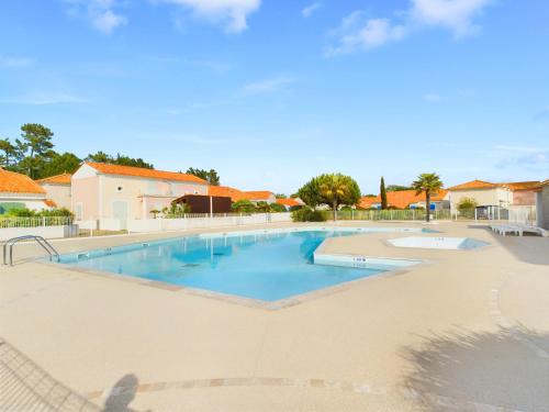 - une grande piscine dans une cour avec des maisons dans l'établissement À 800m de la plage, maison pour 6 avec piscine, à Plage-des-Demoiselles