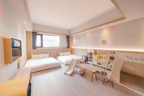 a large room with two beds and a tv at Hotel Liyaou in Chiayi City