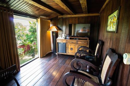 a living room with chairs and a television and a table at Balam Bali Villa in Mengwi