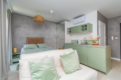 a bedroom with a bed and a kitchen with a couch at APARTAMENTY MIERZEJA - STEGNA PARK STUDIO, 500 m od plaży, bezpłatny meleks in Stegna