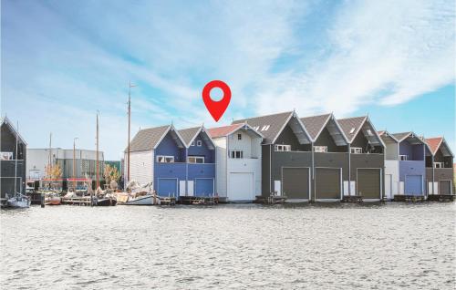 a red marker in front of a row of houses on the water at Waterhuis in Harderwijk