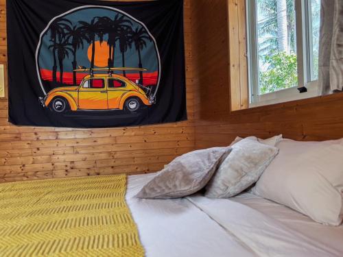a bedroom with a painting of a car on the wall at B&B American Style cabin 5 minutes from the sea in Hengchun