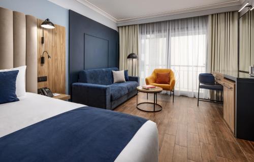 a hotel room with a bed and a chair at Vivaldi Hotel in St Julian's
