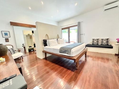a bedroom with a bed in a room with wooden floors at The Apartments Umalas in Canggu