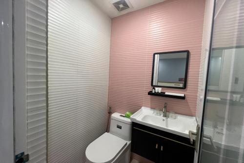a bathroom with a toilet and a sink and a mirror at Qingqing Hotel Pasay Manila near MOA in Manila