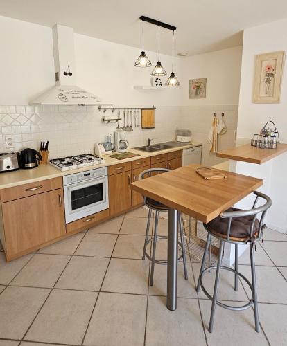 a kitchen with wooden cabinets and a table with chairs at Appartement 1 Maison Régis in Conques-en-Rouergue