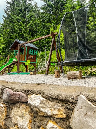 a playground with a slide and a swing set at Vila Bašić Vlašić Spa Apartman JELEN in Vlasic