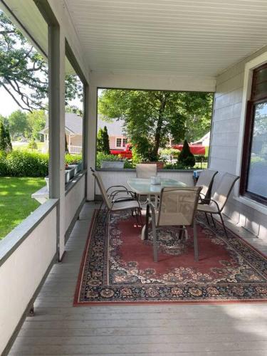 a patio with a table and chairs on a porch at 19 century Victorian Home in Des Moines