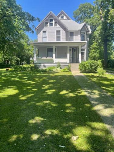 a white house with a large yard with trees at 19 century Victorian Home in Des Moines