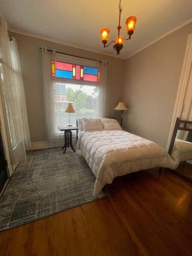 a bedroom with a bed and a window and a table at 19 century Victorian Home in Des Moines