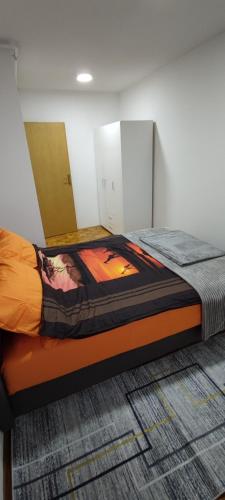 a bedroom with a bed with an orange mattress at Stan Vogosca in Vogošća