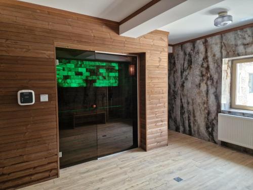 a glass door in a room with a wall with wood at COLT DE RAI-Deluxe & Spa in Reşiţa