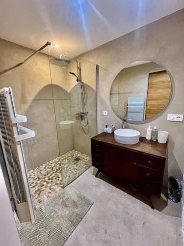 une salle de bain avec un lavabo et une douche avec un miroir dans l'établissement Appartement T3 proche des plages, à Fréjus