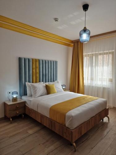 a bedroom with a large bed with blue curtains at COLT DE RAI-Deluxe & Spa in Reşiţa