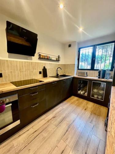 Il comprend une cuisine dotée de parquet, d'un évier et d'un comptoir. dans l'établissement Appartement T3 proche des plages, à Fréjus