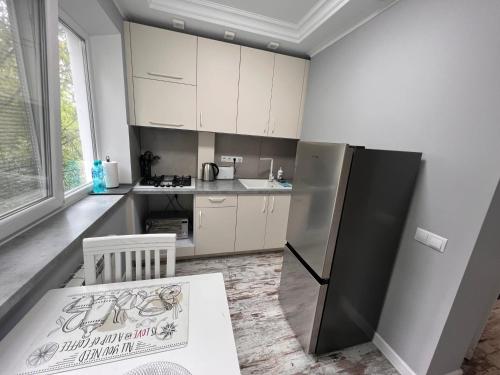 una cucina con mobili bianchi e un frigorifero nero di PerfectRoom3 a Chişinău