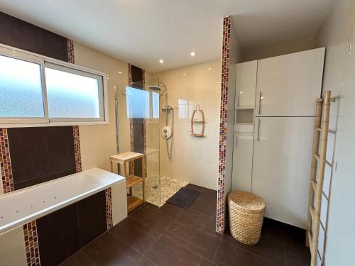 a bathroom with a shower and a sink and a refrigerator at La Roselière - CDDT in Yves