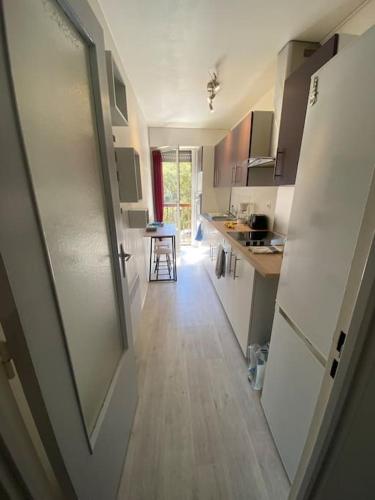 une cuisine avec une porte s'ouvrant sur une cuisine avec une table dans l'établissement Superbe appartement à 150 m plage de la péguière, à Saint-Raphaël