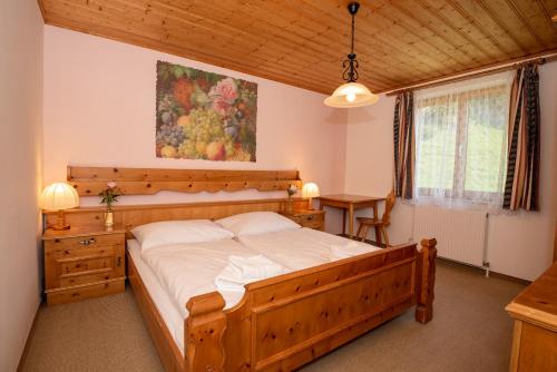 una camera con un grande letto in legno di Hotel Alpen Arnika a Tauplitzalm