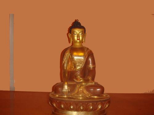 a golden statue of a buddha sitting on a table at Hotel Hana Pvt.Ltd in Kathmandu