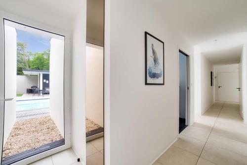 a hallway of a house with white walls and a mirror at Villa avec piscine - 500m de la plage de Rampillon in Longeville-sur-Mer